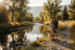 a couple by a river with their dog
